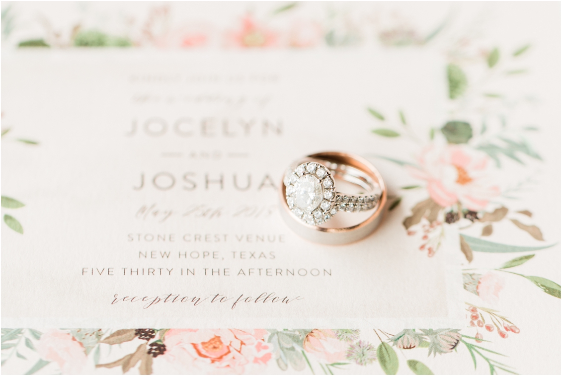details shot of wedding rings on wedding invitation