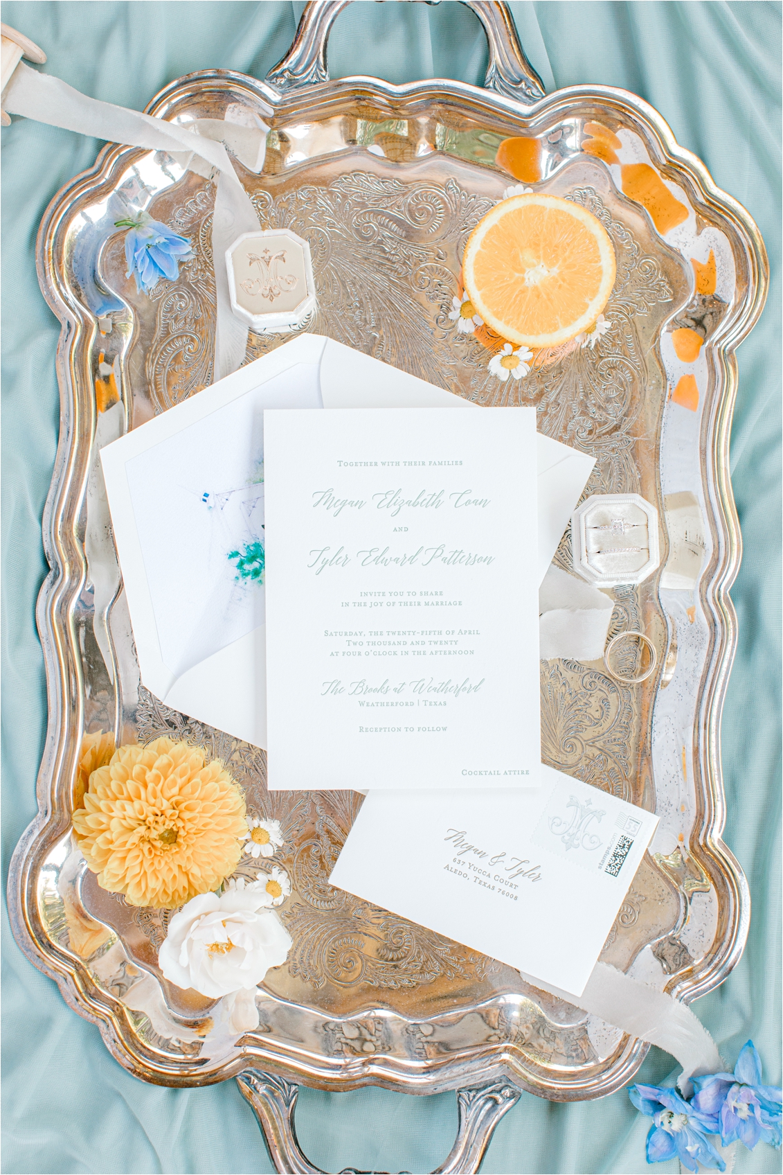 wedding invitation and rings on a vintage tray
